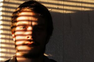 Mann mit Sonne und Schatten im Gesicht, nachdenklich